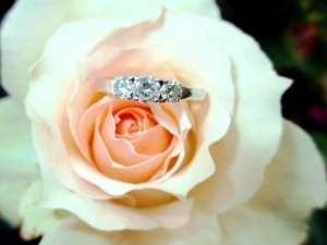 Elegante anello di diamanti posto su una rosa bianca, simbolo di amore e bellezza. Perfetto come regalo di fidanzamento o matrimonio, esalta il fascino dei gioielli in oro e diamanti.