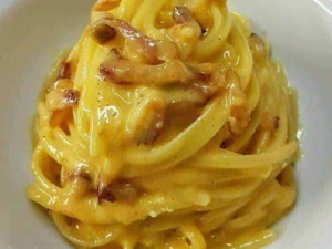 Crema di pancetta e formaggio su spaghetti carbonara, piatto italiano classico, cucina autentica, ricetta tradizionale.