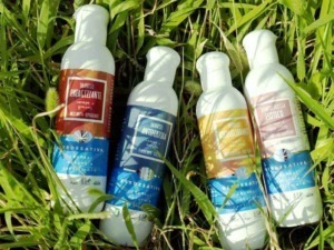Shampoos naturali per capelli in bottiglie di plastica in giardino, con etichette colorate di erbe e ingredienti naturali. Ideali per trattamenti dermatologicamente testati e efficaci.