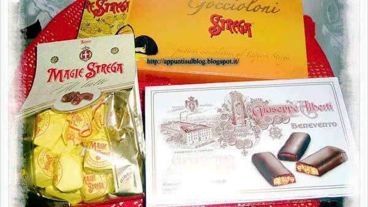Dolci tipici italiani: cioccolatini Magic Strega e Gnocchi di Baba con ricetta tradizionale, presentati su un vassoio rosso, accompagnati da volantini promozionali e un sito web di riferimento.