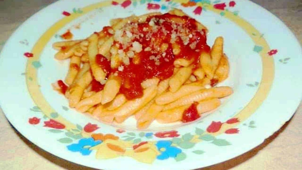 Pennette con sugo di pomodoro e parmigiano, piatto di pasta italiana tradizionale. Pastasciutta con salsa di pomodoro, ideale per la cucina casalinga.