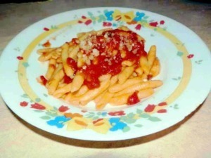 Pennette con sugo di pomodoro e parmigiano, piatto di pasta italiana tradizionale. Pastasciutta con salsa di pomodoro, ideale per la cucina casalinga.