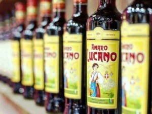 Amaro Lucano bottiglie di liquore tradizionale italiano in fila sugli scaffali di un negozio.