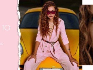 Una donna di stile in abiti rosa seduta su un'auto gialla, con trucco audace e occhiali rosso scuro, raffigurata in un contesto di moda e lifestyle.