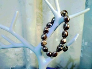 Bracciale di perle nere su ramo decorativo bianco, accessori moda eleganti, bijoux sofisticati, gioielli di lusso, idea regalo esclusiva, stile glamour e raffinato, tendenza gioielleria femminile.