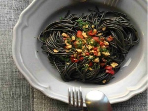 Spaghetti nero di seppia con olio, aglio, prezzemolo e peperoncino, piatto di pasta elegante e saporito, cucina italiana autentica, ingredienti freschi, presentazione invitante.