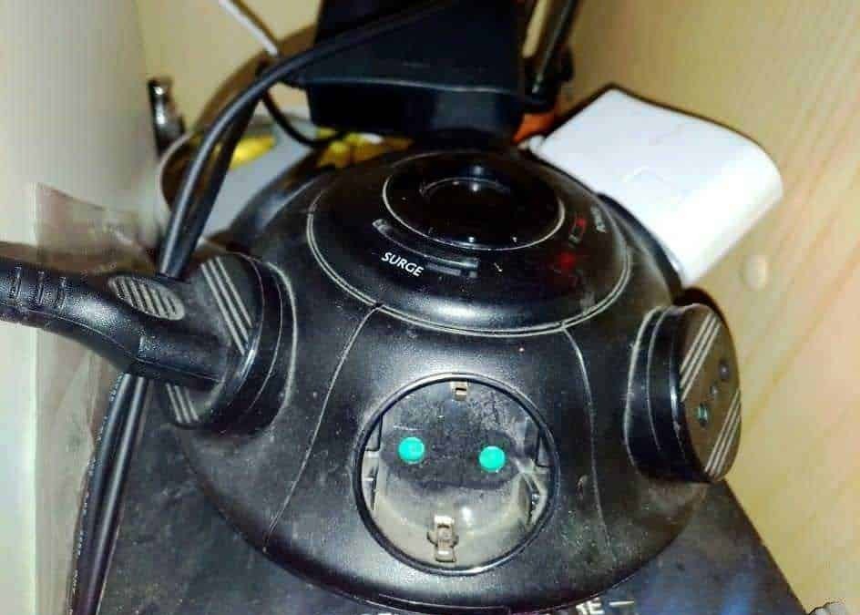 Plugged-in vacuum cleaner with power cord and control buttons on a modern device for home cleaning.