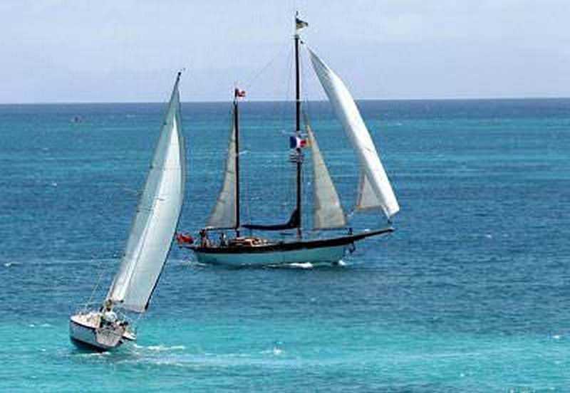 Antigua chiama Italia, terra magica tra cielo e mare 5 Vela a mare con barca a vela tradizionale e moderna che naviga sul mare blu, immagine di navigazione, avventura e relax in mare aperto.