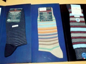 Sottobicchieri di calzini da uomo con vari colori e fantasie, mostra modelli italiani e di alta qualità, collezione di calze classiche e alla moda per uomo, ideali anche come regalo elegante.