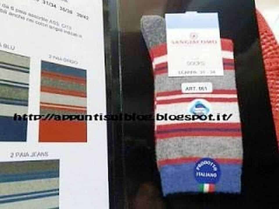 Valigia in tessuto con strisce colorate, logo "Prodotti Italiano" e etichetta "ART. 001" su sfondo nero, ideale per rivista tessile, moda o produzione di accessori italiani. Design pratico e di qualità.