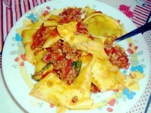 Pasta fresca con ragù di carne e verdure, piatto tradizionale italiano, cucinato e servito in un piatto decorato con fiore e colori vivaci, forchetta a fianco, atmosfera casalinga e autentica.