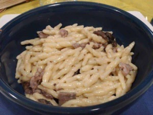Creamy pasta con carne in una ciotola nera, un piatto di comfort food italiano ricco di formaggio e sapore. Perfetto per una cena semplice e gustosa.