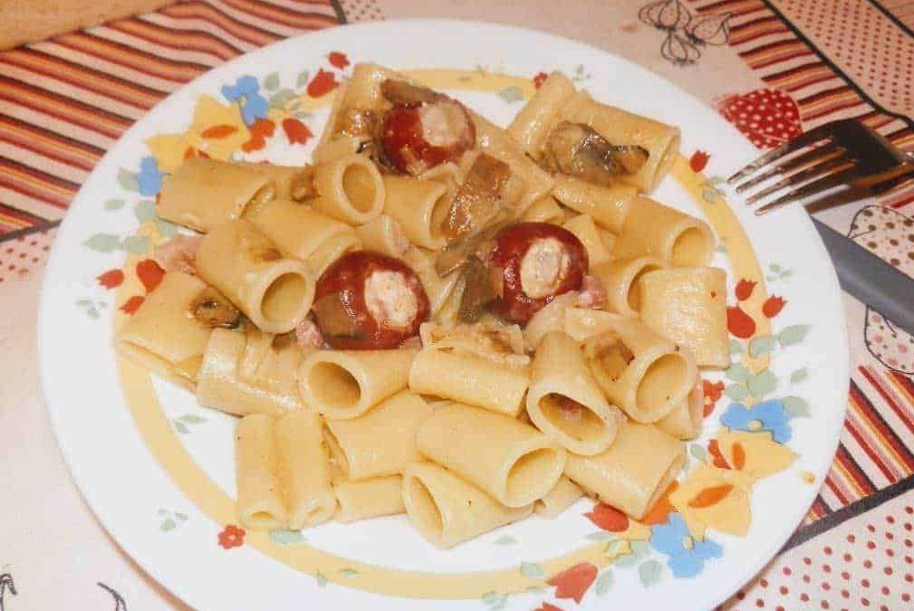 Pasta rigatoni con salsiccia e funghi, piatto di cucina italiana, spaghetti ripieni di carne, food experience, ricetta tradizionale, appetitoso e gustoso.