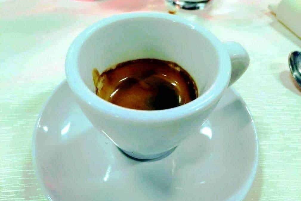Calice di Espresso con crema intensa, servito in tazza bianca elegante su piattino, perfetto per gli amanti del caffè, in ambiente raffinato e accogliente.