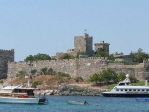 Castello storico con imbarcazioni in mare, vista panoramica di fortezza medievale su costa, turismo nautico e paesaggi costieri, località turistica in Italia, Appunti Sul Blog.