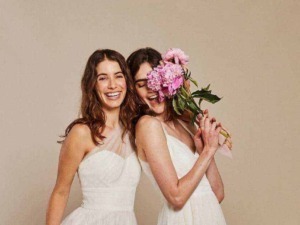Ragazze in abito bianco con fiori, sorridenti e felici, atmosfera di amicizia e gioia, ideale per contenuti di lifestyle, moda, e momenti speciali.