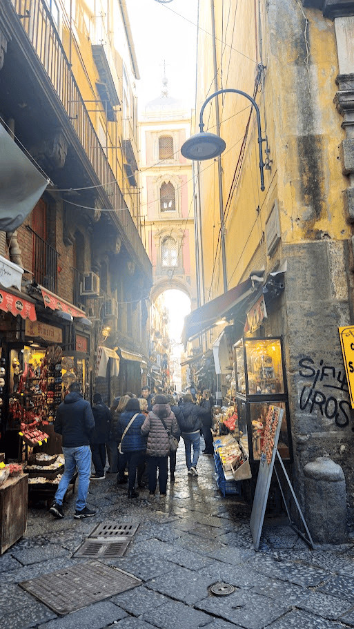 La Fiera dei Presepi .Vicolo affascinante di Napoli con negozi di street food e souvenir, creando un'atmosfera vivace e autentica, ideale per chi cerca un'esperienza culturale e locale.