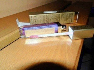 Profumo di Donna - Flacone di profumo con bottiglia in vetro rosa e scatola di confezione elegante sul tavolo di legno.