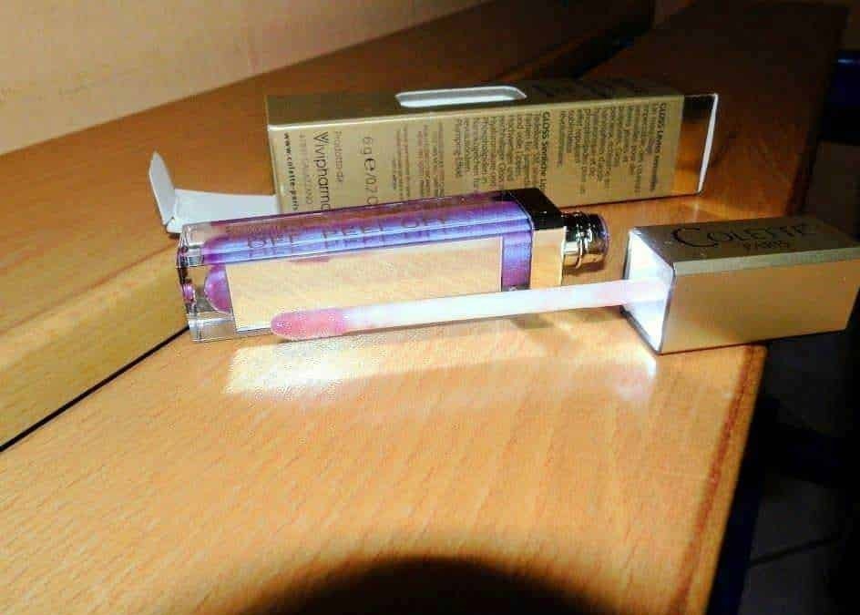 Profumo di Donna - Flacone di profumo con bottiglia in vetro rosa e scatola di confezione elegante sul tavolo di legno.