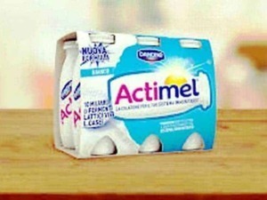 Actimel yogurt probiotici, confezione da sei pezzi, su tavolo di legno.