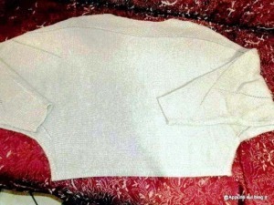 Tessuto di maglia bianca per produzione di abbigliamento, disposto su sfondo rosso con motivi floreali. Ottimo esempio di tessuto per la moda e il design di moda contemporaneo.