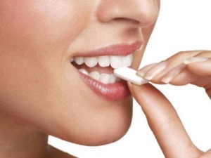 Dentista che tiene in mano una compressa di cotone vicino ai denti, immagine di igiene orale e cura dentale.