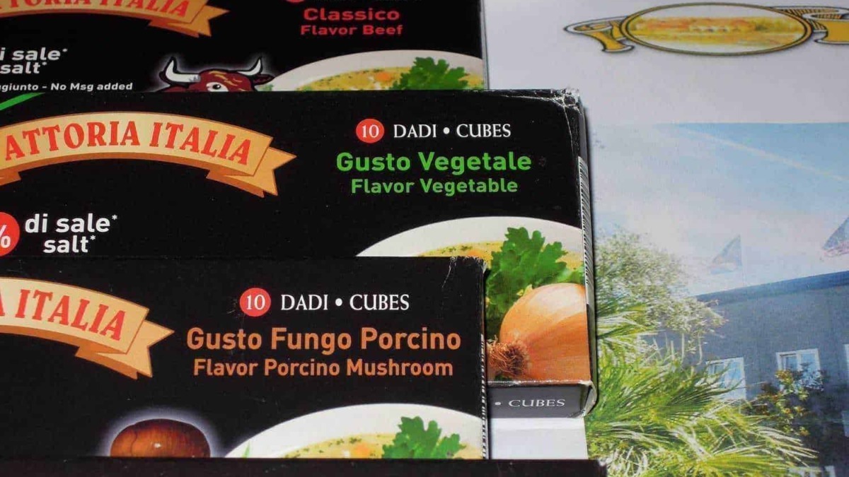 Cubetti di dadi con gusti vegetale, porcino e bovino, confezioni di brodo per cucina, ideali per ricette italiane, focus su ingredienti naturali e sapori autentici.