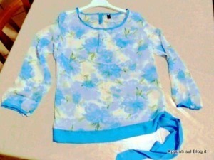 Femminile maglione a fiori azzurri e gialli su appendiabiti, moda donna primavera estate, vestito casual, outfit colorato, style floreale, eleganza femminile.