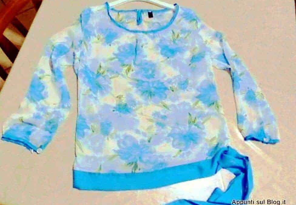 Femminile maglione a fiori azzurri e gialli su appendiabiti, moda donna primavera estate, vestito casual, outfit colorato, style floreale, eleganza femminile.