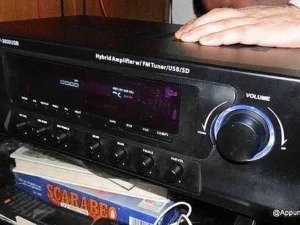 Amplificatore stereo con tuner FM e lettore USB SD, controlli di volume e equalizzatore, posizionato su una scrivania con libri e accessori audio, ideale per impianti hi-fi domestici.