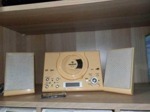 Radio stereo vintage con casse acustiche su scaffale in legno, dispositivo audio analogico, perfetto per musica e radio.