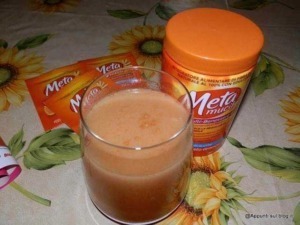 Metamucil integratore alimentare naturale per il benessere digestivo, in polvere arancia, su tavolo con prodotti per la salute, vicino a bicchiere di bevanda aranciata.