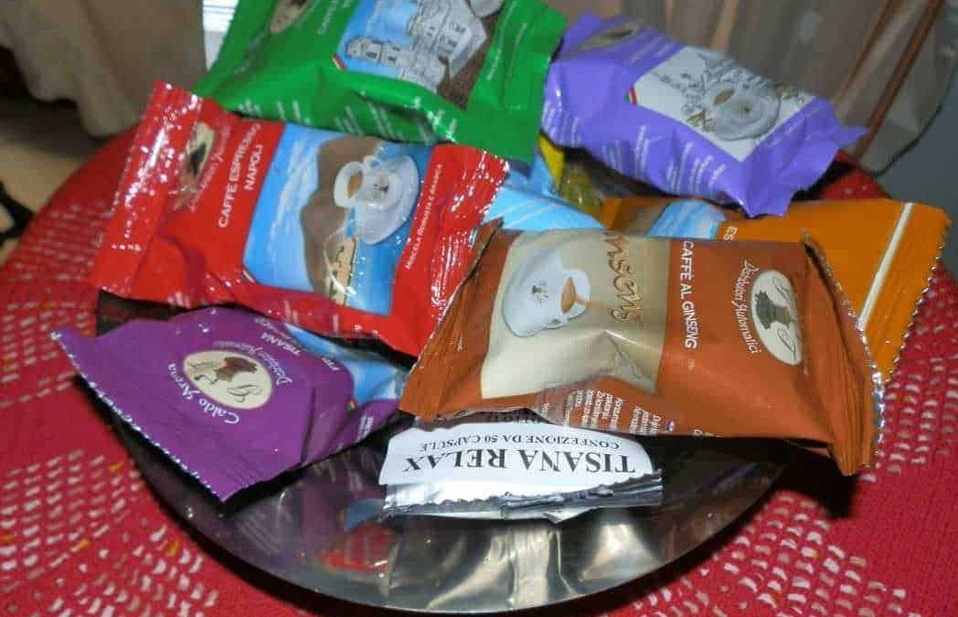 Fiocchi di tè aromatico di diverse varianti in sacchetti colorati disposti su un piatto.
