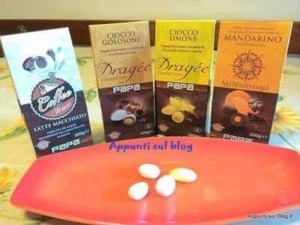 Latte macchiato in polvere con profilo aromatico, accompagnate da cioccolatini e cioccolato fondente, ideali per momenti di dolcezza e relax.