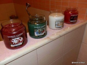 Collezione di candele profumate Yankee Candle in vari aromi e colori, posizionate su una superficie in un ambiente domestico. Ideale per creare un'atmosfera accogliente e rilassante in casa.