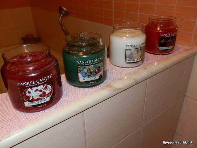 Collezione di candele profumate Yankee Candle in vari aromi e colori, posizionate su una superficie in un ambiente domestico. Ideale per creare un'atmosfera accogliente e rilassante in casa.