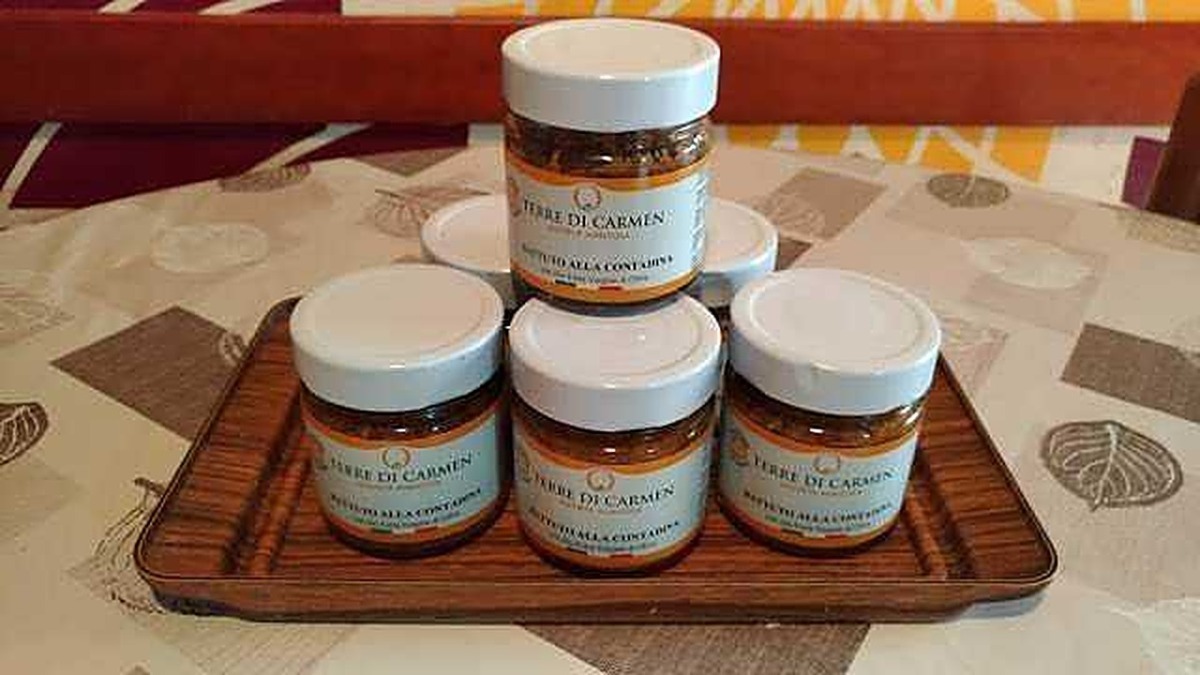 Crema biologica di Tebaure di Carmen in piccoli vasetti su vassoio di legno, prodotto artigianale naturale.