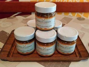Crema biologica di Tebaure di Carmen in piccoli vasetti su vassoio di legno, prodotto artigianale naturale.