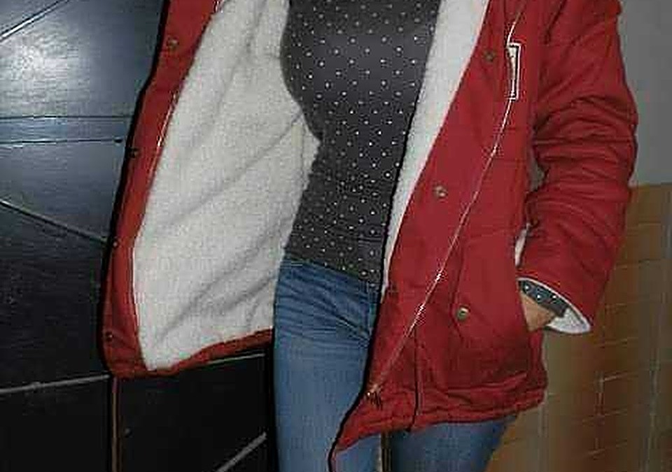 Scarpa invernale donna con interno peloso, giacca rossa con cappuccio e punte in pelliccia, jeans blu, outfit casual elegante in inverno.