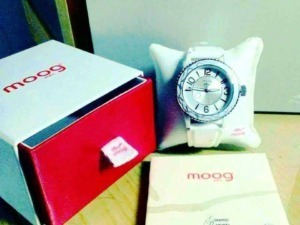 Orologio da polso con cinturino bianco, confezionato con cura e presentato su un cuscino bianco, accompagnato da scatola e manuale di garanzia, ideale come accessorio di moda elegante.