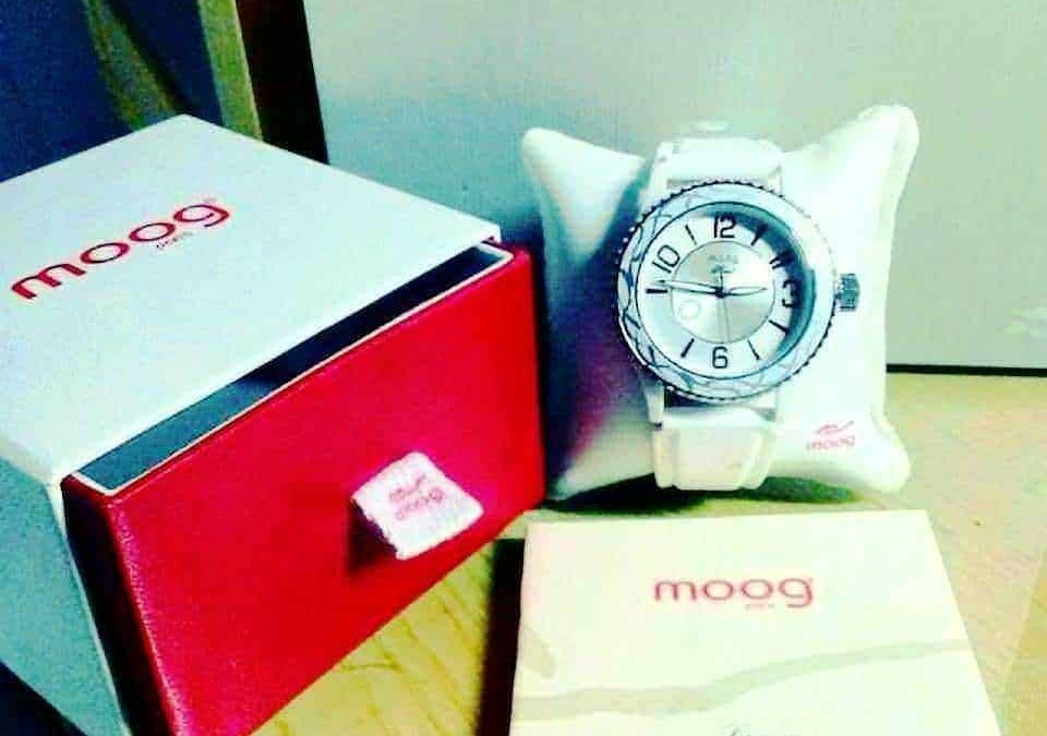 Orologio da polso con cinturino bianco, confezionato con cura e presentato su un cuscino bianco, accompagnato da scatola e manuale di garanzia, ideale come accessorio di moda elegante.