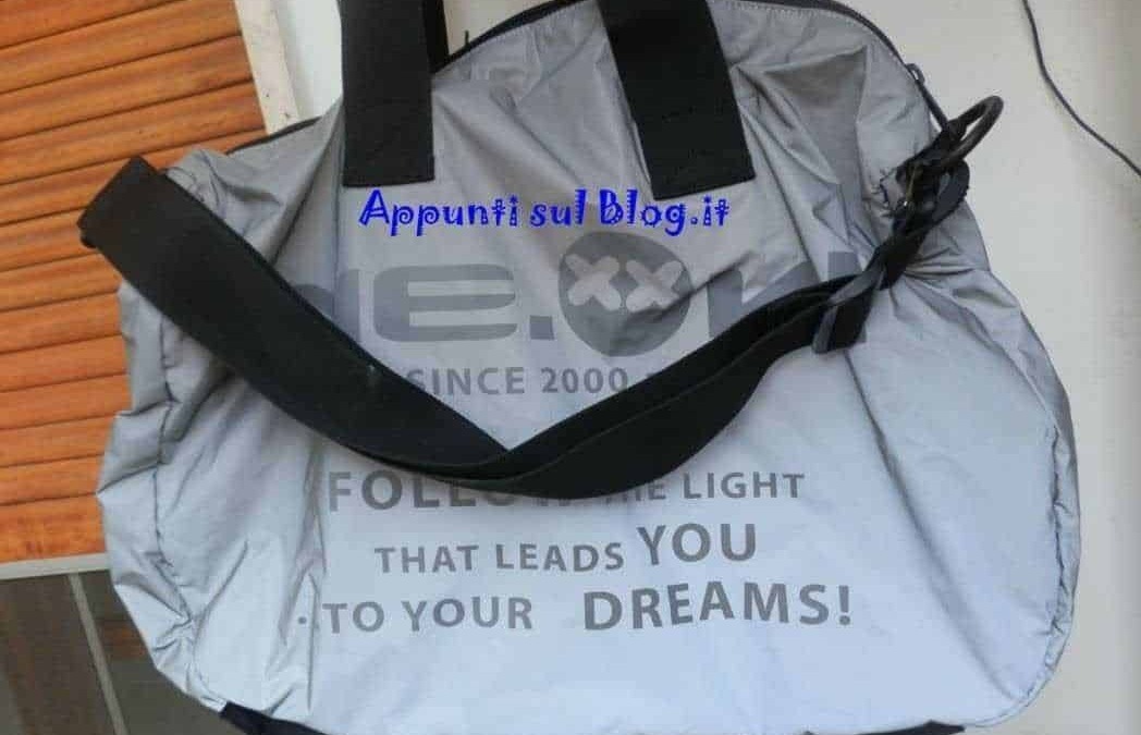 Borsa da viaggio in nylon grigia con scomparto principale e manici robusti - logo e citazioni motivazionali, adatta a viaggi e attività sportive.