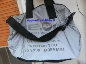 Borsa da viaggio in nylon grigia con scomparto principale e manici robusti - logo e citazioni motivazionali, adatta a viaggi e attività sportive.