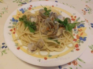 Vongole e spaghetti freschi preparati con ingredienti di alta qualità, serviti in un piatto decorato con erbe aromatiche, ideale per un pranzo di mare autentico e saporito.