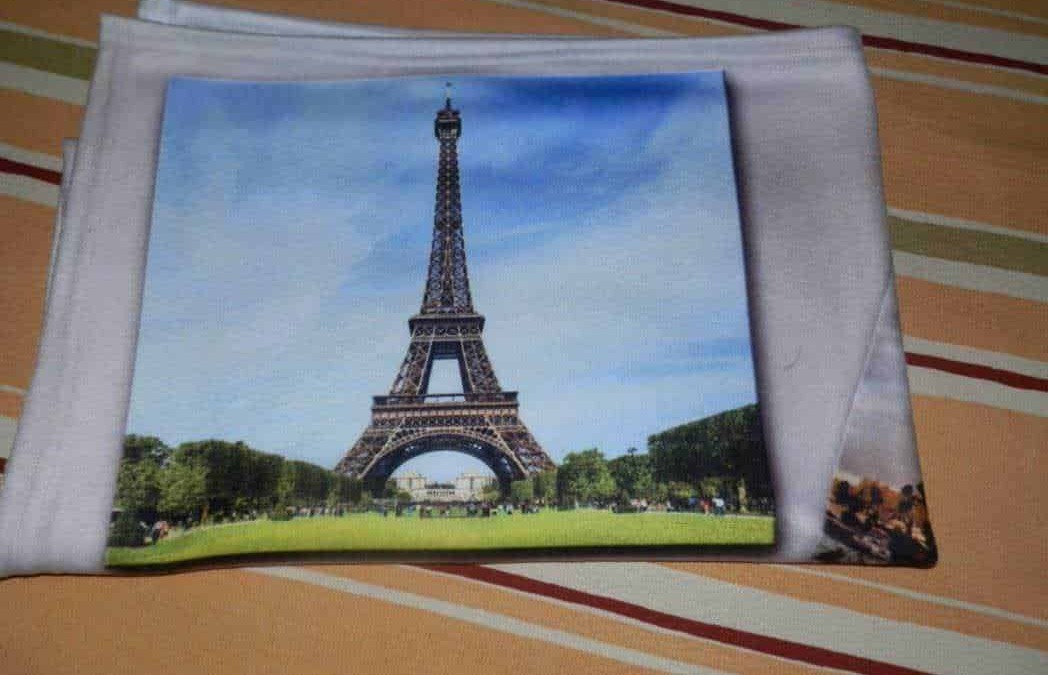 Plaidmania: Pila con immagine della Torre Eiffel stampata su un tessuto bianco, ideale come souvenir decorativo per chi ama Parigi e l'arte.