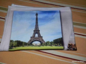Plaidmania: Pila con immagine della Torre Eiffel stampata su un tessuto bianco, ideale come souvenir decorativo per chi ama Parigi e l'arte.