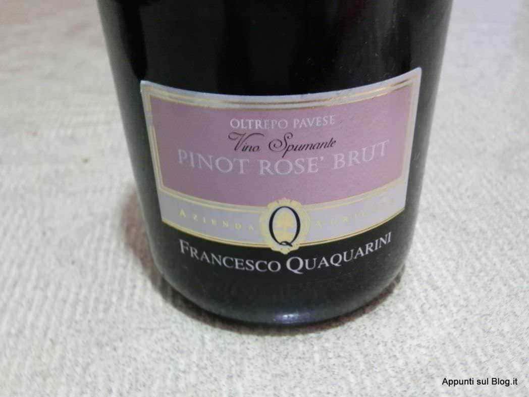 Vino rosso e spumante su tavolo con bottiglie di vino e calice pieno, atmosfera elegante per degustazione di vini italiani.