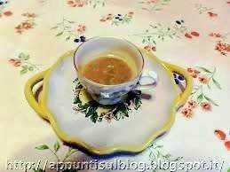 Tazza di tè con piattino decorativo floreale su tovaglia colorata, dettaglio di un momento di relax e convivialità.