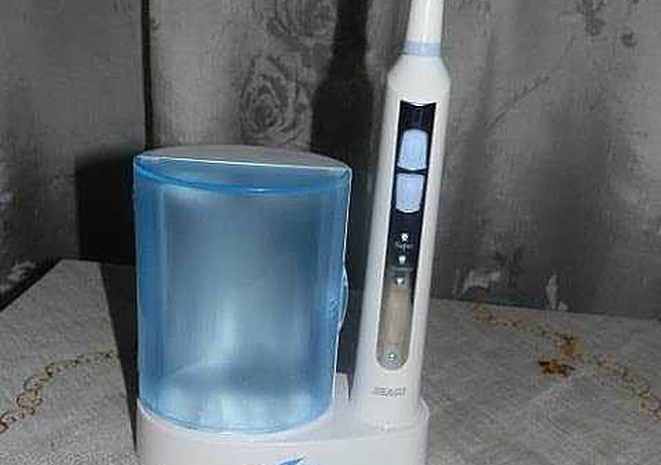 Spazzolino elettrico con base di ricarica e accessori per l'igiene orale, ideale per una pulizia efficace dei denti.