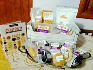 Maiscrizione di biscotti e prodotti da forno artigianali, inclusi pasticcini, pasta frolla e ingredienti per dolci, presentata in un cesto di legno.